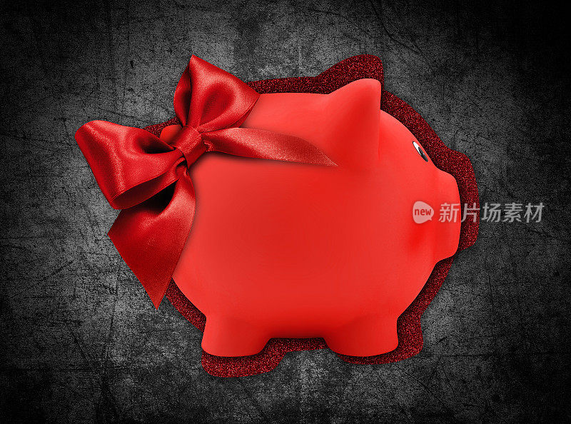 礼品卡标签在一个红色的小猪银行的形状与红色闪光丝带蝴蝶结孤立在黑色的背景