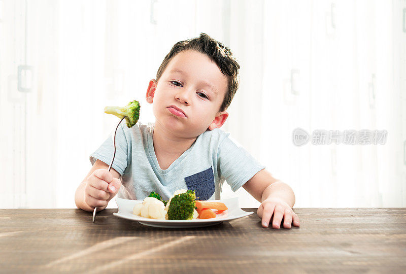 孩子对不得不吃蔬菜很不高兴。