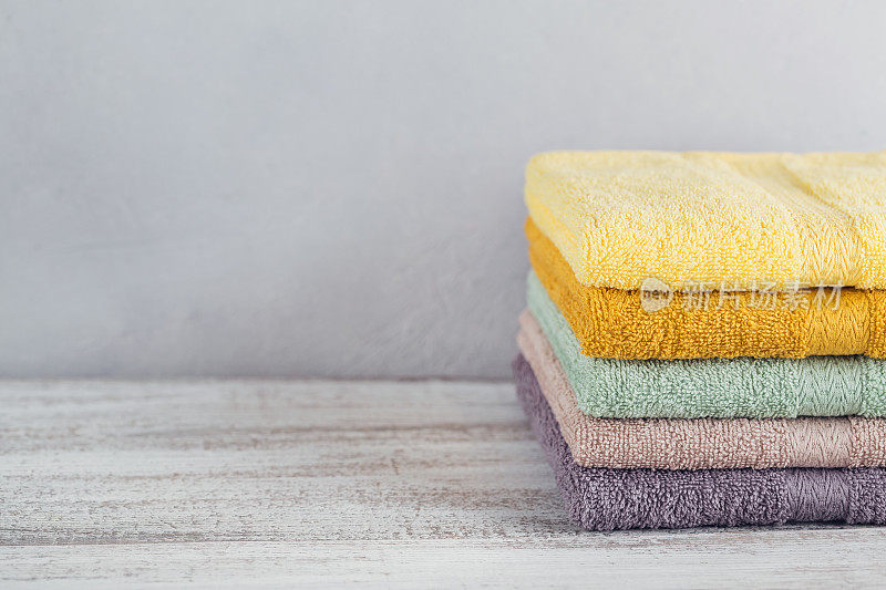 颜色鲜艳的浴巾堆叠在灯光背景上。