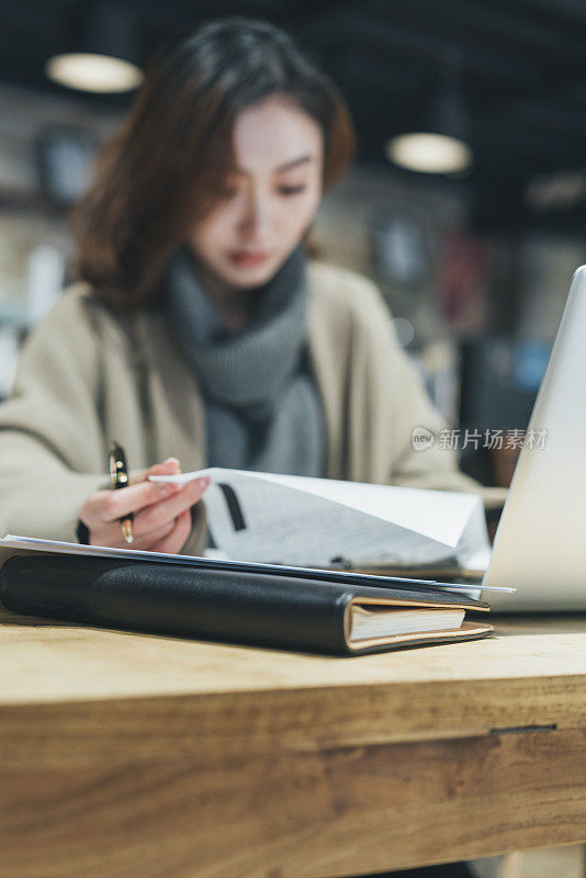 在咖啡店里用笔记本电脑做文书工作的女人
