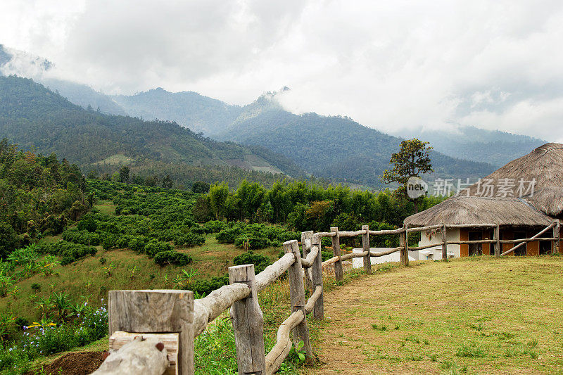 风景优美的山，木栅栏的前景和房子的背景。云来，派，泰国。