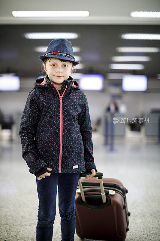 带着行李箱在机场旅行的漂亮女孩