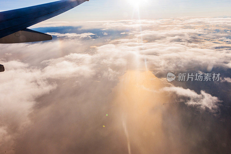 飞机机翼在窗口飞行，多云的天空