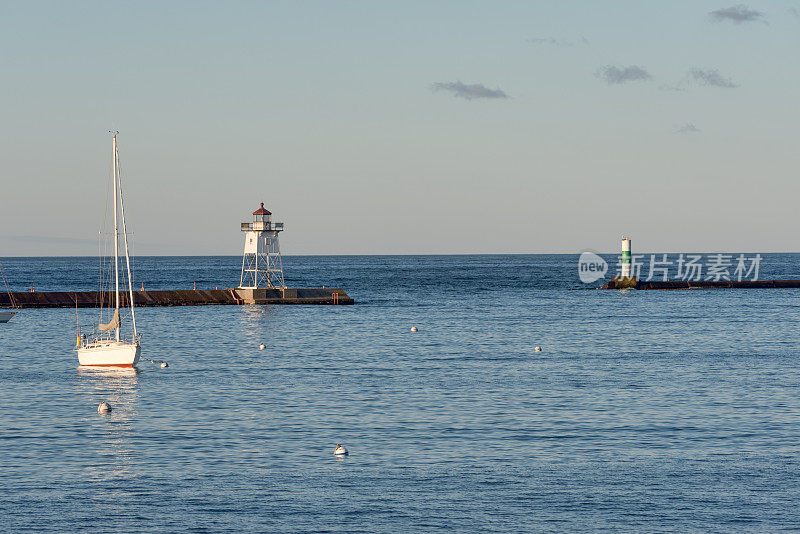苏必利尔湖港口上的灯塔和帆船