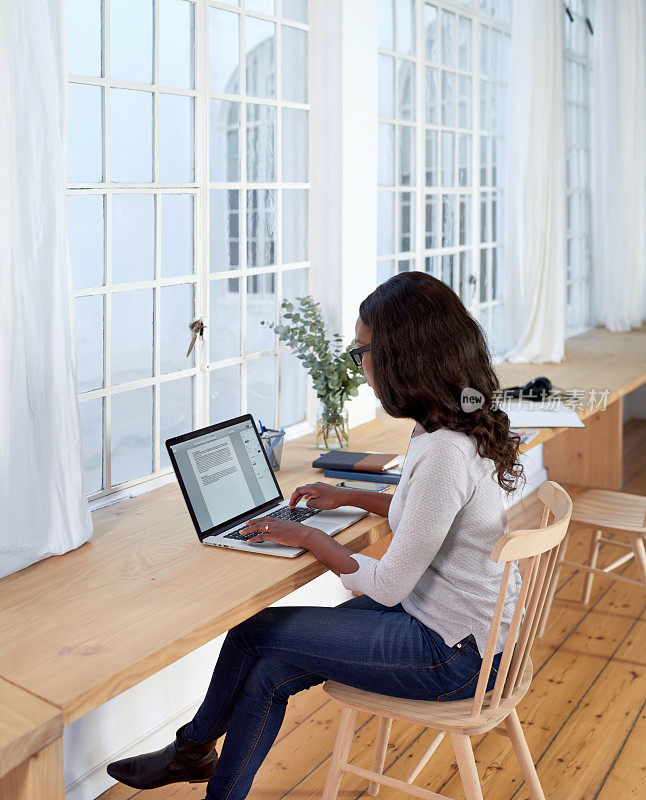 独立自信的女人在电脑上打字在家工作