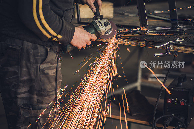 一个在工厂里用手锯焊接烙铁的不可辨认的手工工人。