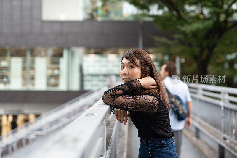 一名女子走在表参道大街上，这是日本最著名的街道之一