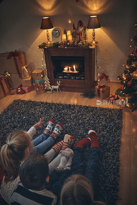 可爱的孩子们穿着圣诞袜坐在舒适的气氛中