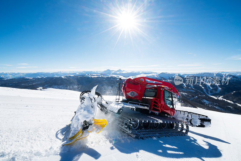 现代的红色雪清理多余的雪从滑雪道，因为太阳照耀明亮