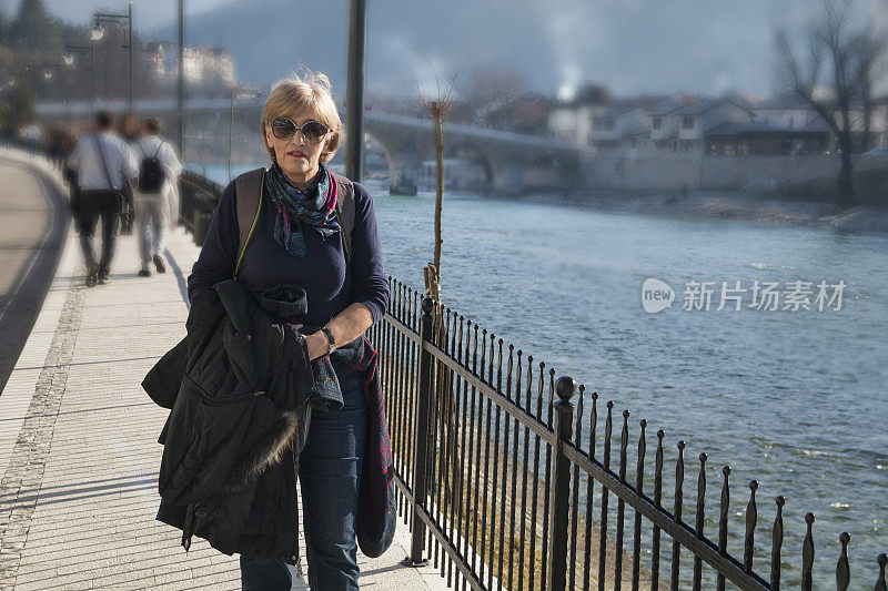 一个美丽的女人在春天阳光明媚的日子里散步