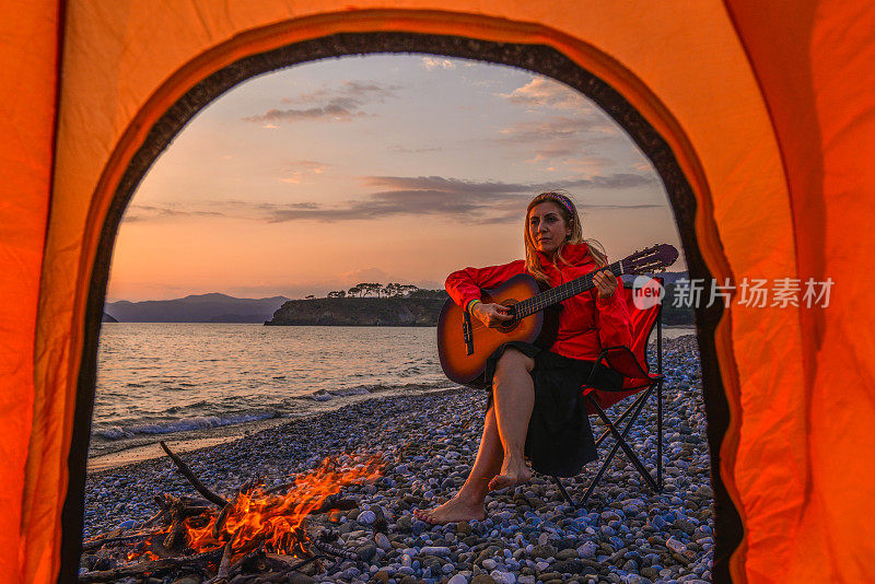 在海滩上弹吉他的女人。