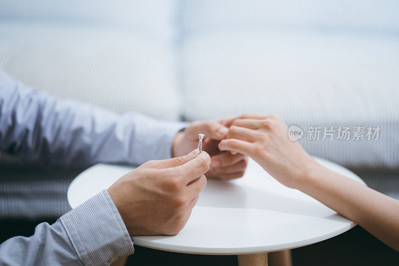 一男子戴着订婚戒指在新房子里向女友求婚