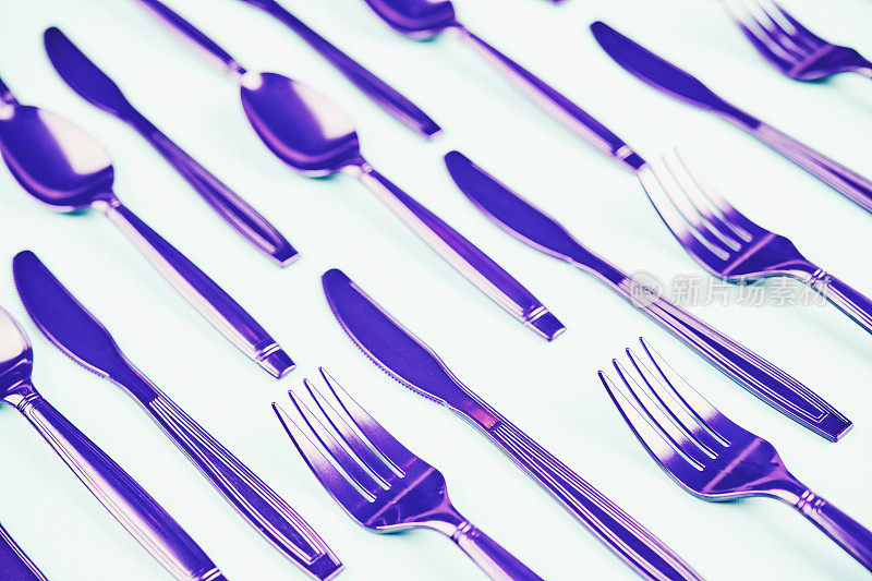 平铺背景与紫色的叉，刀和勺子