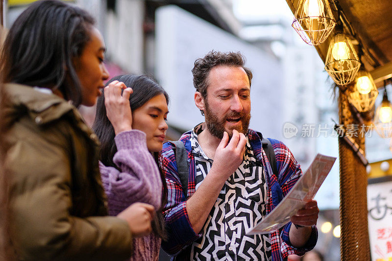 游客在餐馆前看菜单