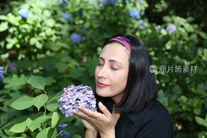 女人在闻绣球花。