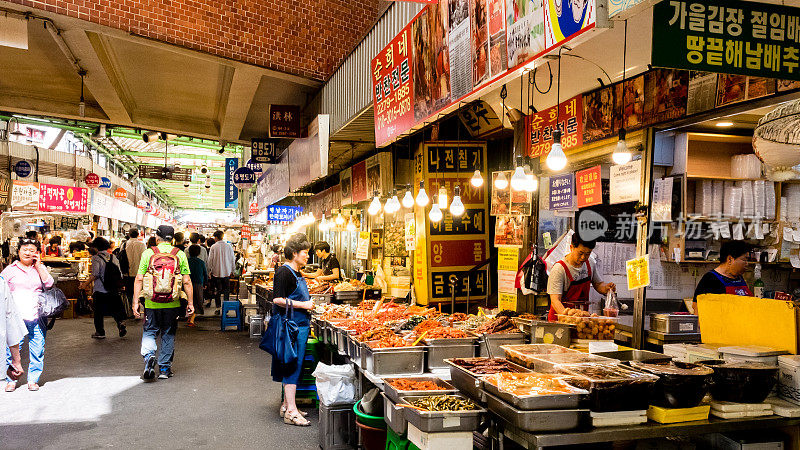 一名妇女在首尔的光江市场购买食物。