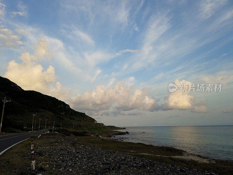 越南孔岛的空旷蜿蜒的乡村公路全景。日落时的汽车旅行。蓝天，云和山。Condao岛屿。