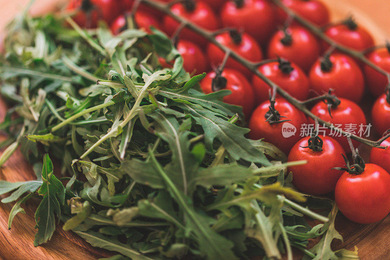 木盘上的樱桃番茄和芝麻菜，特写