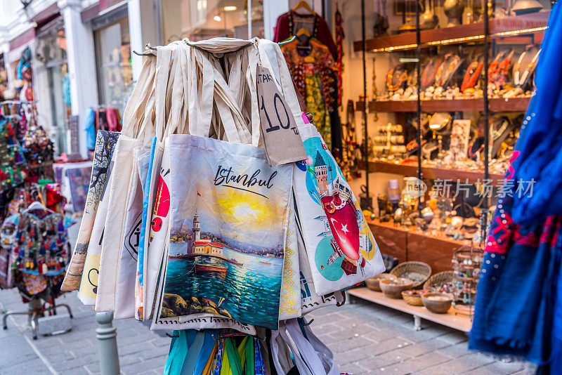 在土耳其伊斯坦布尔一个繁忙的夏天，在五颜六色的纪念品和礼品店前的纺织袋礼物