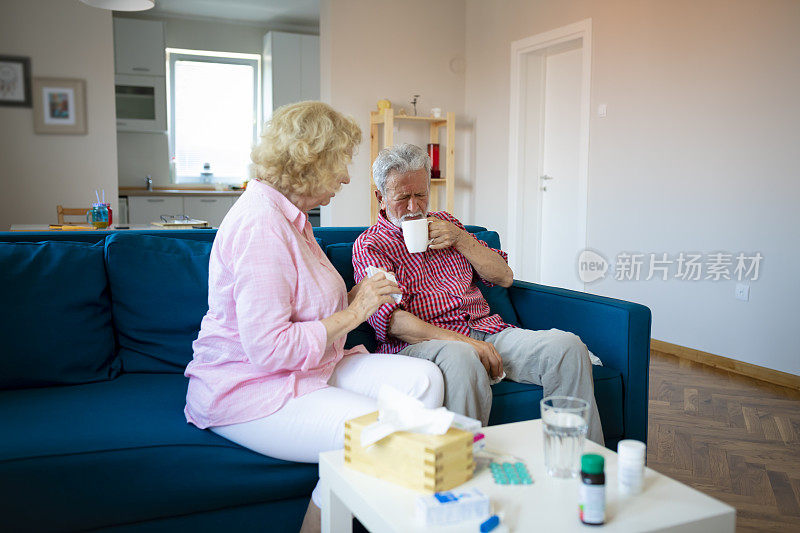 当她们坐在客厅的沙发上时，一位老妇人帮助生病的丈夫。她给他吃药，照顾他。