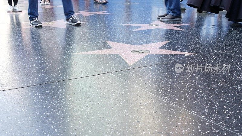 洛杉矶好莱坞大道上的星光大道。在柏油路上靠近明星的行人。杜比和TCL中国剧院附近的走道