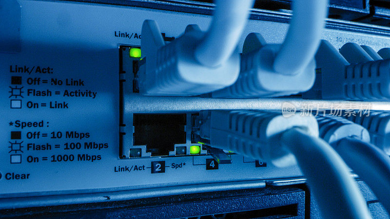 近距离微距拍摄以太网电缆连接到路由器端口与闪烁灯。电信:RJ45设备连接器插入调制解调器集线器。安全的数据中心。
