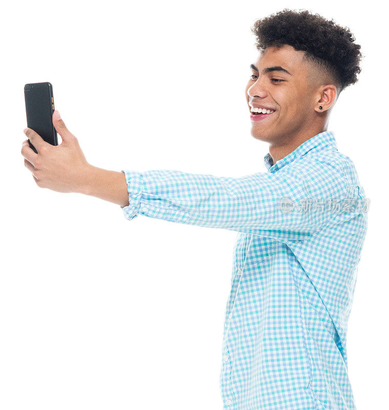 非裔美国男性穿着卷起的袖子，使用智能手机站在白色背景前拍照