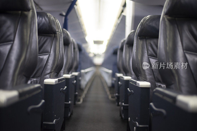 一架商业飞机上一排排空着的头等舱座位。