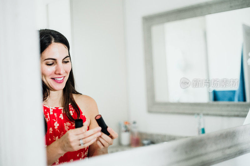 迷人的女人在她的三十多岁在家里的浴室化妆