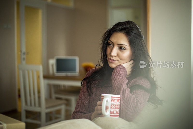 美丽的女士坐在沙发上喝着茶-下午活动在家里的空闲时间-人们的生活理念