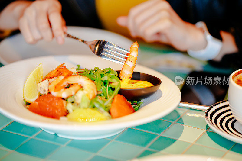 年轻的亚洲年轻女子在餐厅享受新鲜食物的肖像。