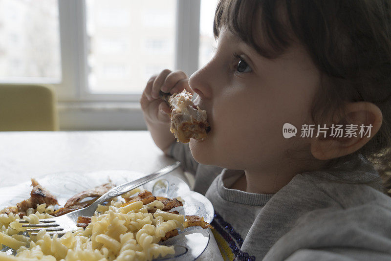 小女孩正在吃鸡肉