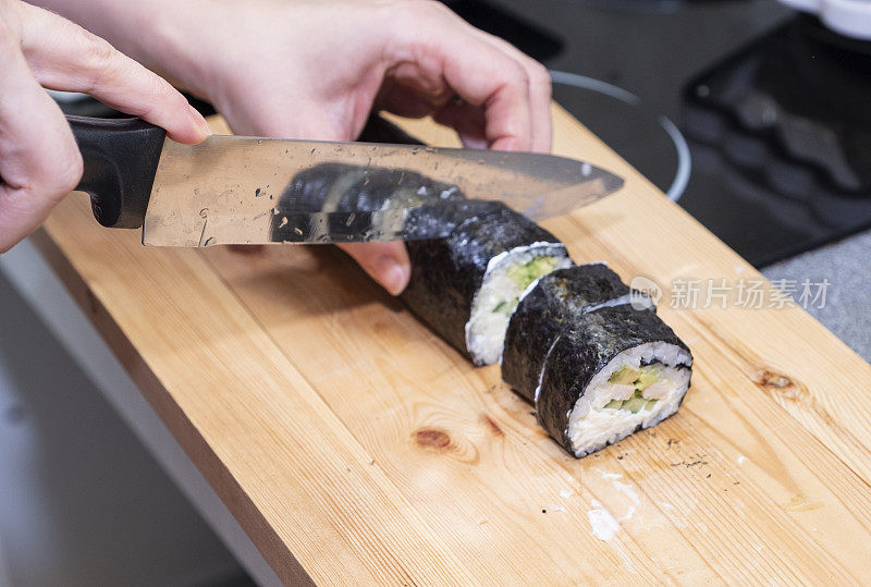 女孩的手正在准备寿司卷。日本料理在家。