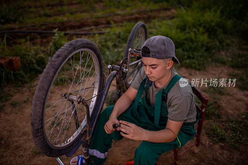 十几岁的男孩，正在修自行车休息