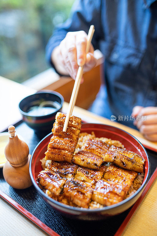 近距离拿起日本烤鳗鱼(Unagi)与筷子