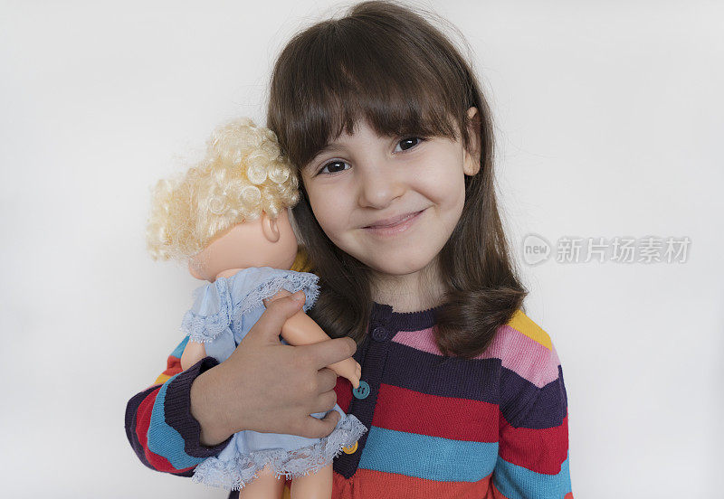 小女孩抱着她心爱的洋娃娃