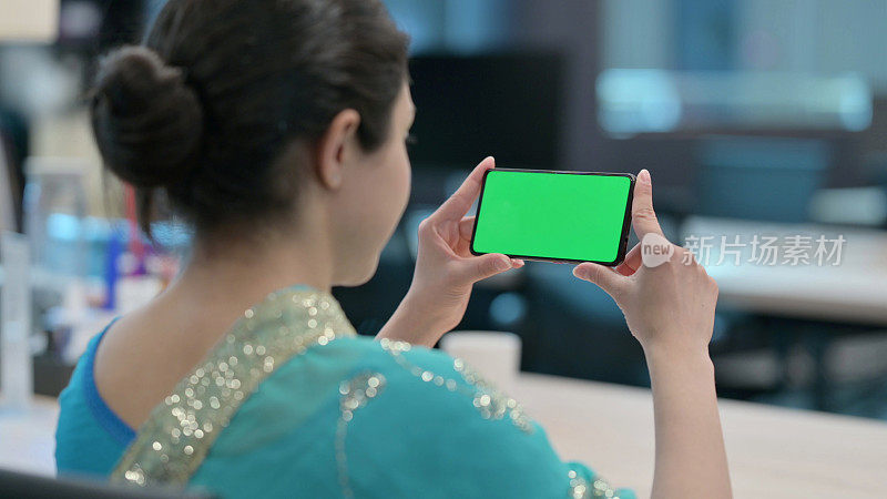 印度女人在看带有色度键屏幕的智能手机