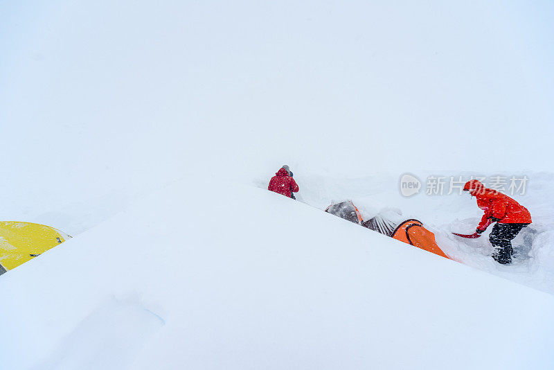 朋友们从又深又细的雪中挖出帐篷