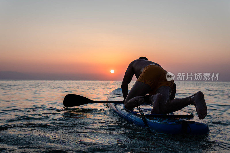 日落时男子划桨的剪影