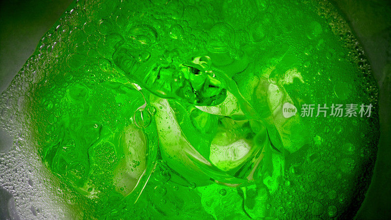 绿色饮料放入装有冰块的玻璃杯中