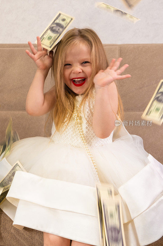 钞票落在一个穿着白裙子的金发女孩身上。金钱雨。财富
