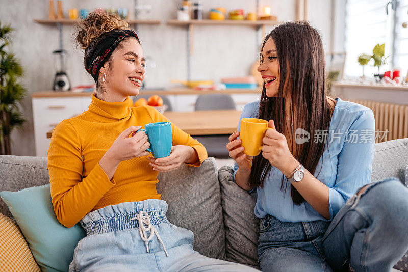 两个女性朋友一边喝咖啡一边聊天
