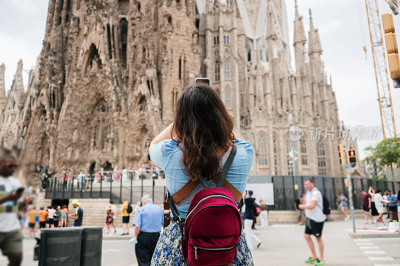 在巴塞罗那圣家堂前拍照的女游客