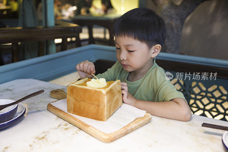 小男孩正在开心地吃面包