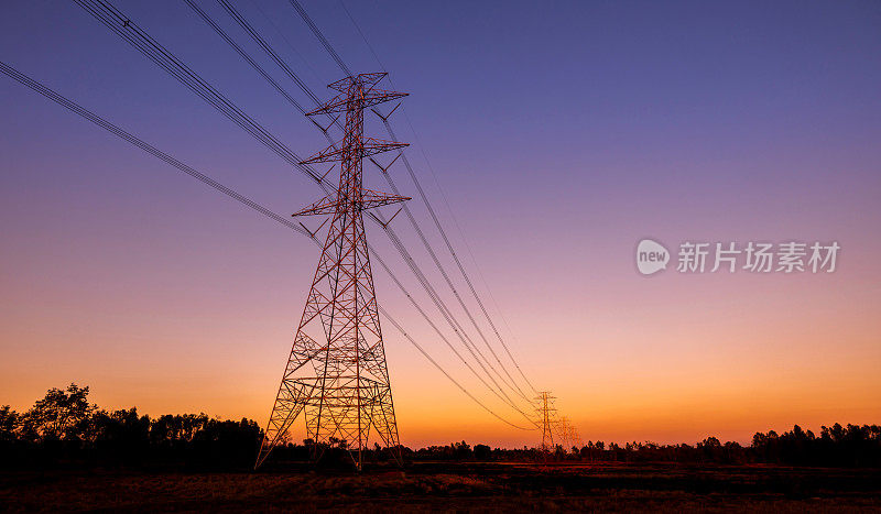黑山上工业电线杆、路灯柱、电线杆、高压塔的剪影。高压输电杆对早晨的太阳背景。
