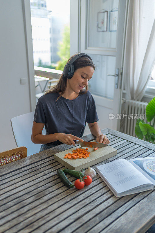 年轻女子一边做饭一边听录音