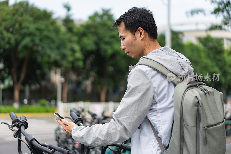 一名男子正在用手机扫描支付共享单车费用