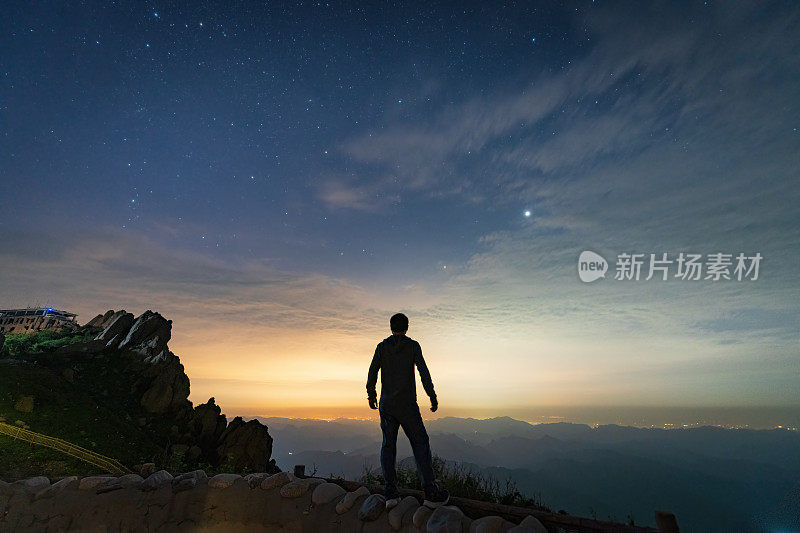 孤独的人在山顶上俯视着城市的夜景