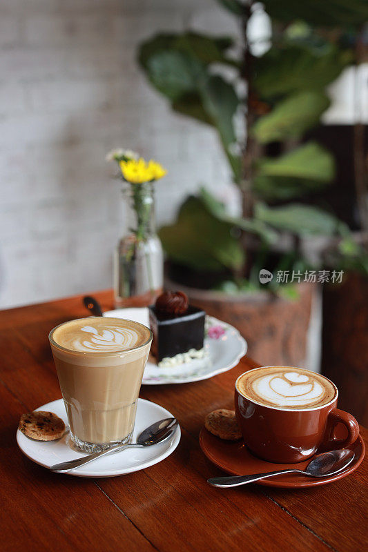 甜点巧克力蛋糕和两杯咖啡放在咖啡桌上，分享食物。