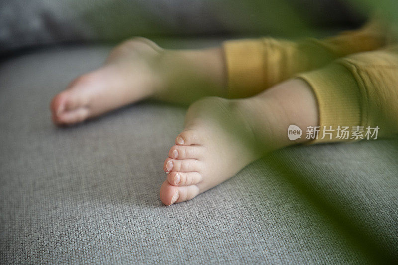 孩子的脚睡在沙发上。白天小睡一下，近距离观察。